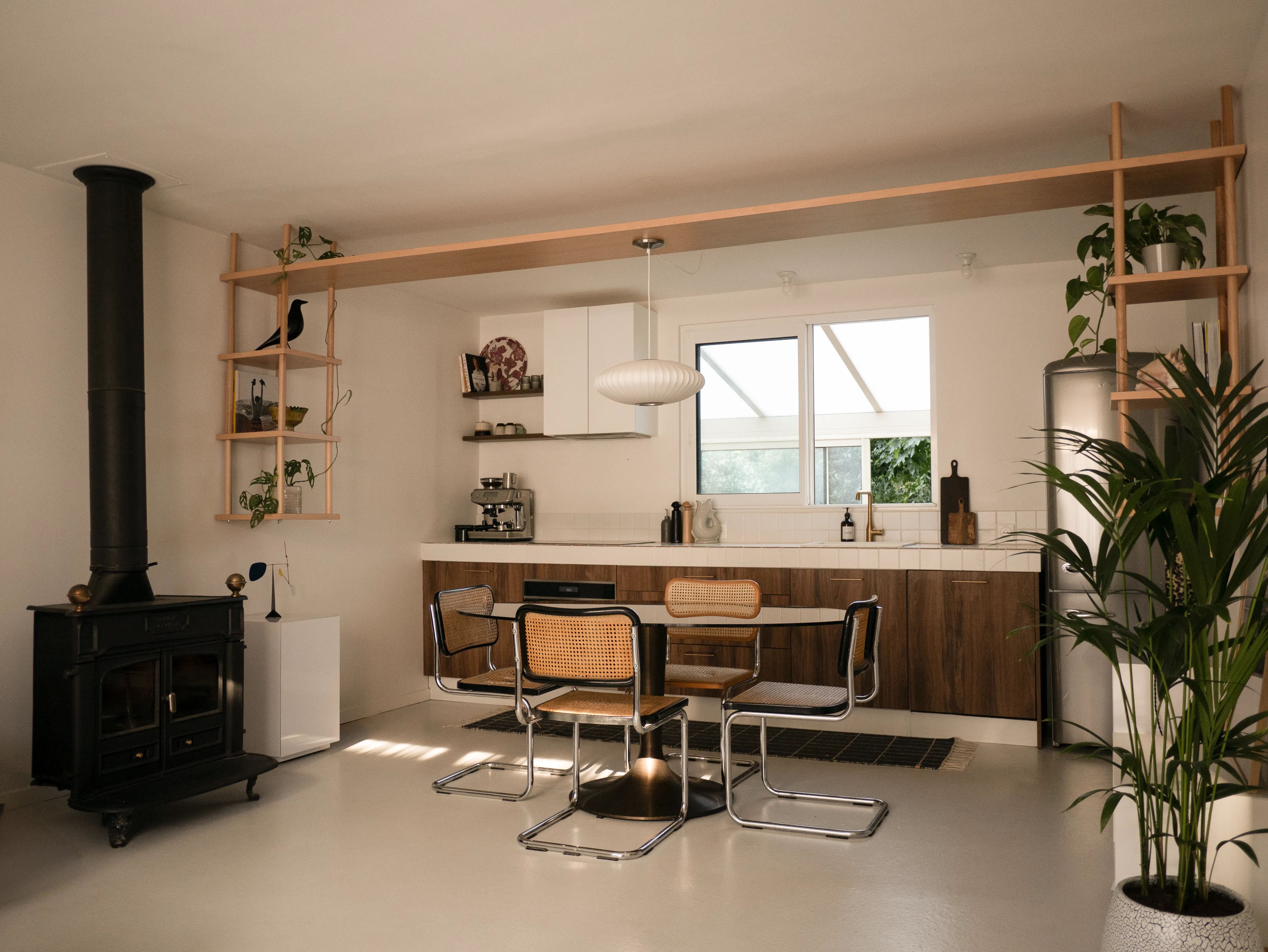 Plan large de la cuisine du projet Léonard, avec structure en bois suspendue délimitant l’espace repas et salon
