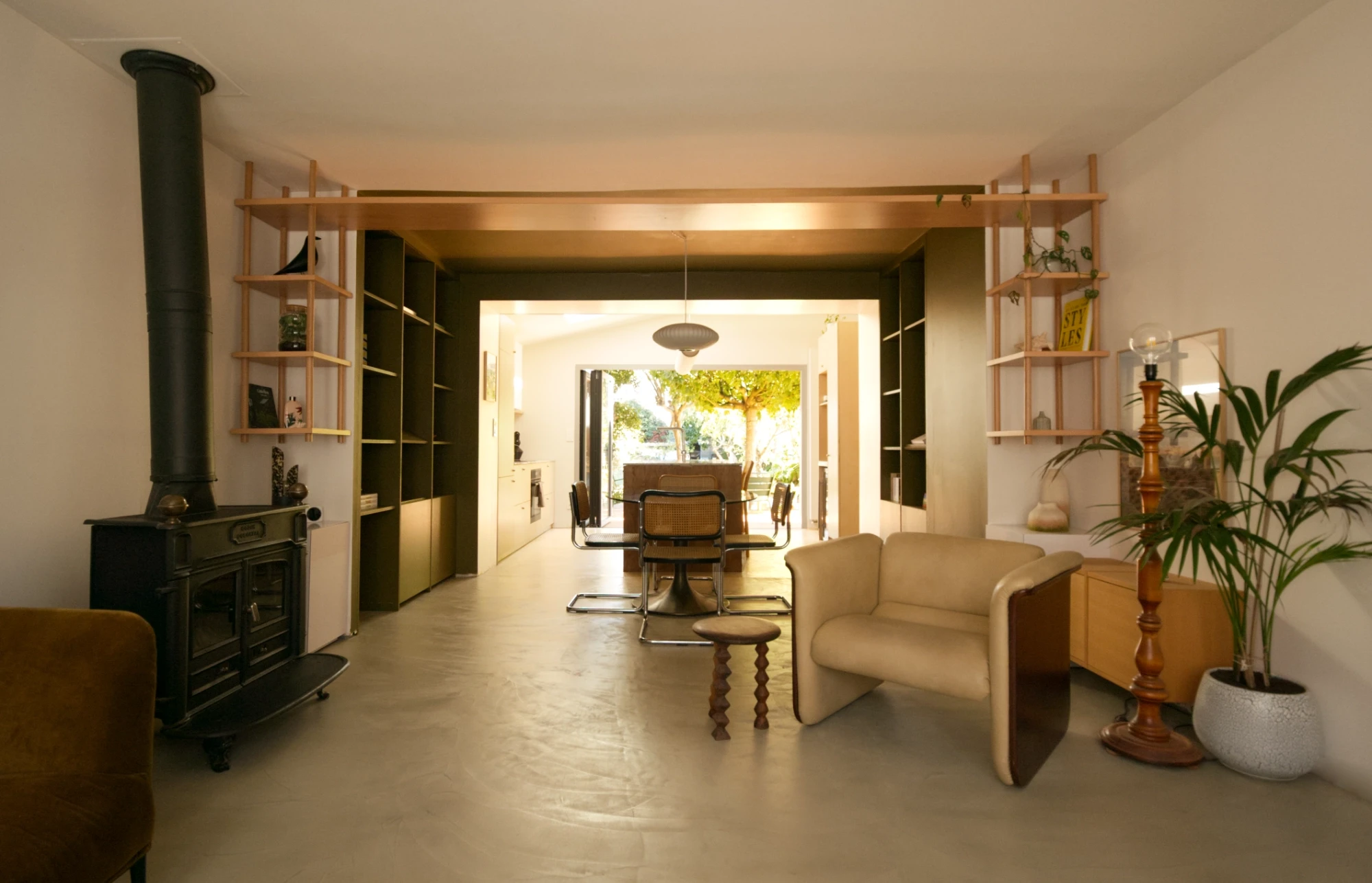 Détail de la décoration minimaliste de la cuisine du projet Leloyer. Focus sur une applique murale en verre soufflé. L'applique est positionnée juste au dessus d'une étagère en bois clair. Deux petits bols en céramique complètent la décoration.