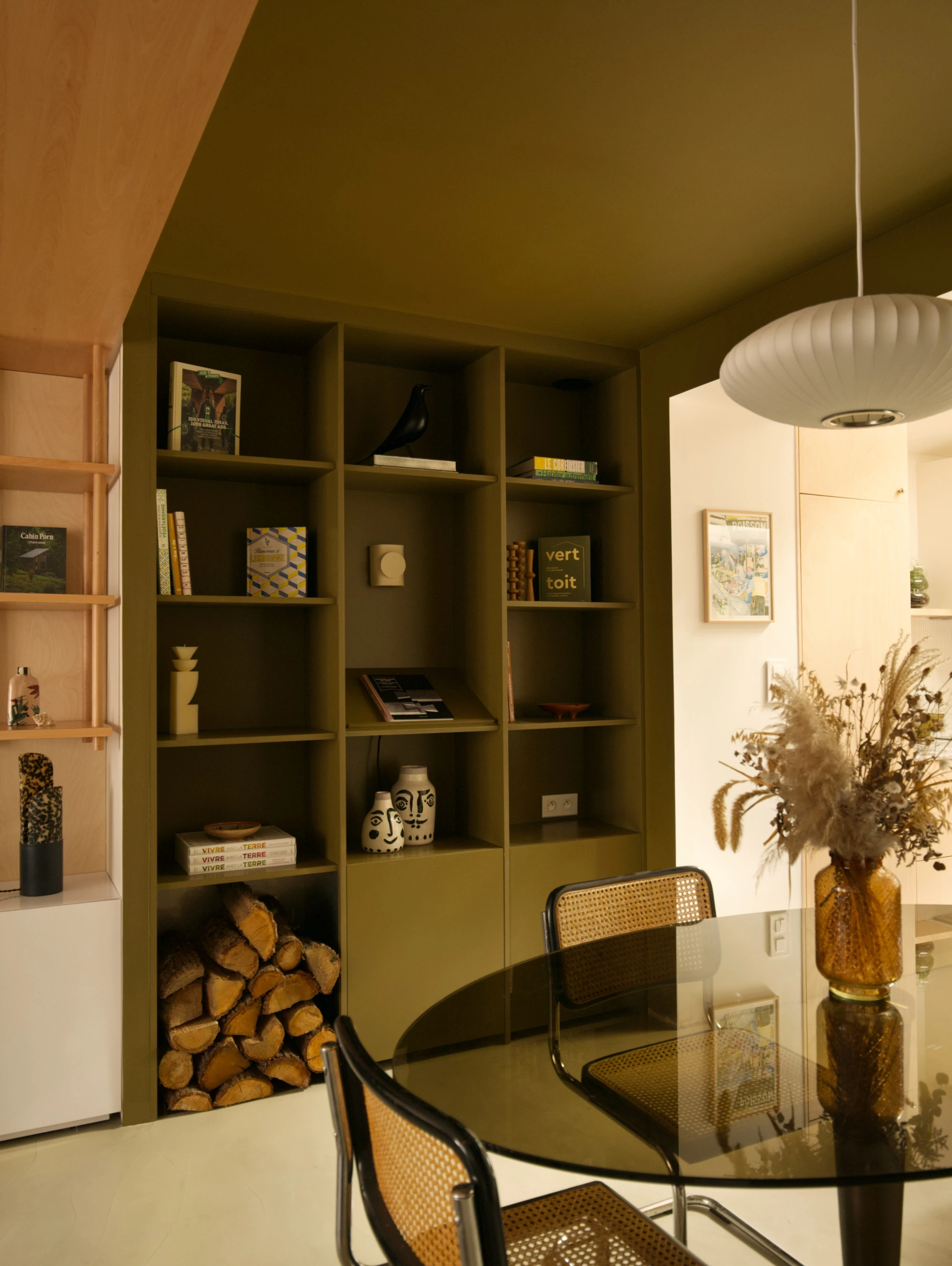 Dans ce projet de rénovation, la délimitation de l'espace grâce à la couleur sur les murs et le plafond permet d'apporter du dynamisme à l'espace en abaissant ponctuellement le plafond pour créer une zone intimiste dans cette salle à manger.