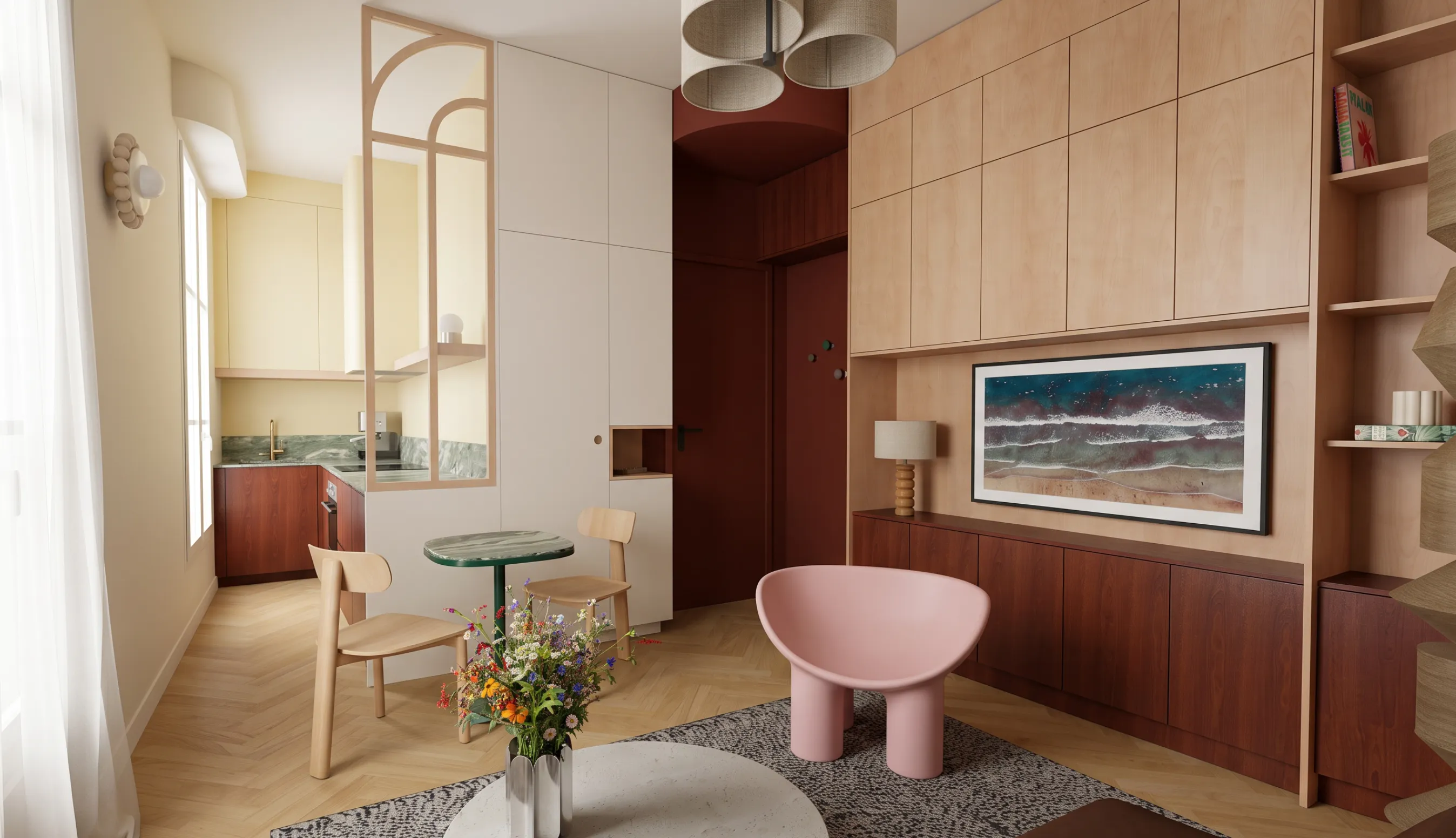 Vue d'ensemble d'un séjour d'appartement ancien rénové : cuisine ouverte derrière une verrière en bois, porte d'entrée bordeaux sous arche, agencement bois clair et acajou sur mesure, fauteuil rose et parquet à bâton rompu.