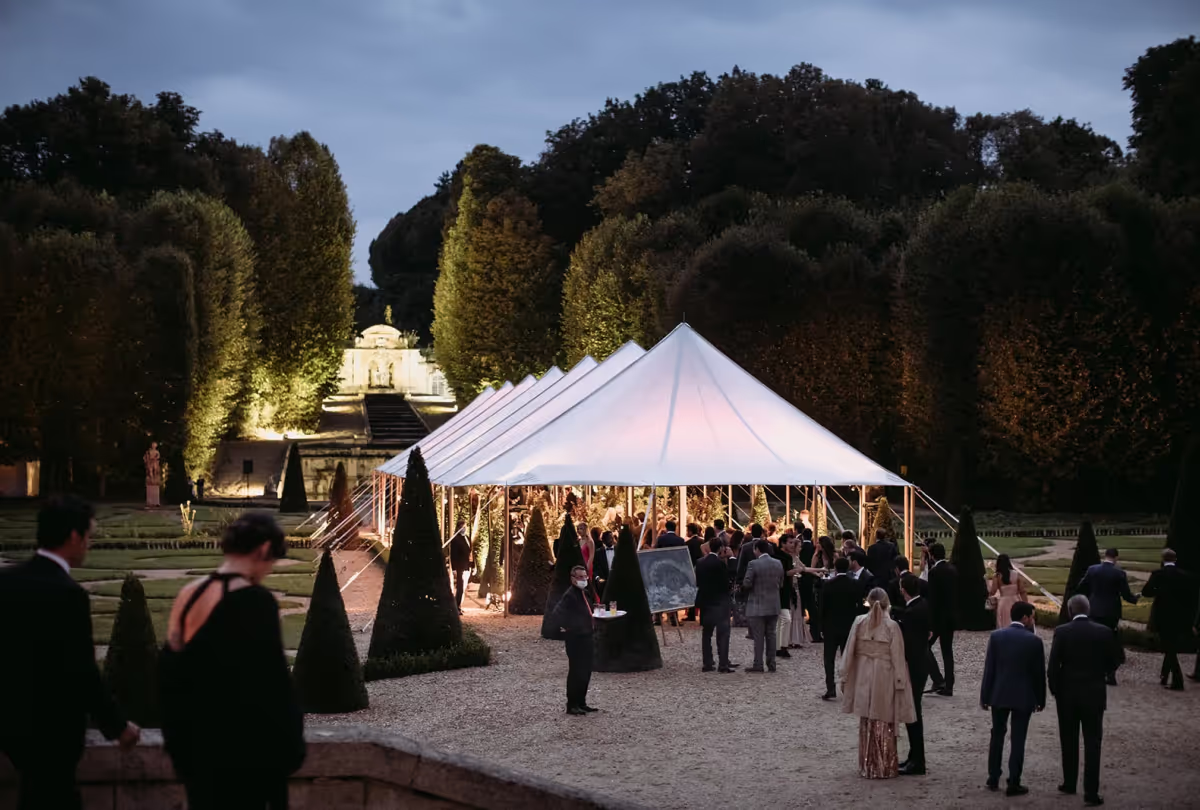 Photo d'une tente chapiteau d'un somptueux mariage dans un château en soirée.