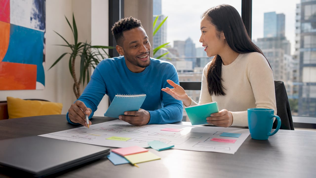 Two marketers collaborating on whiteboard messaging plan