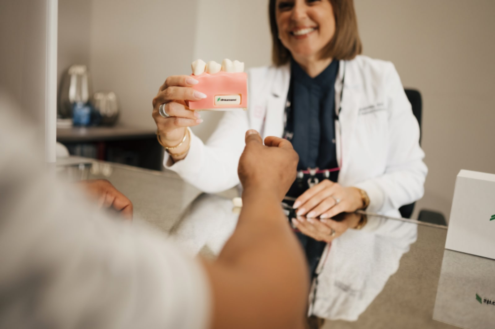 Dentist in white coat consulting with male patient during consultation appointment