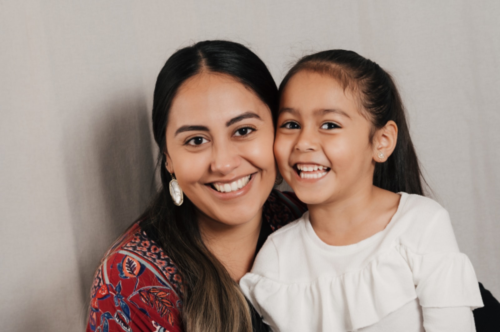 Mother and daughter smiling together in dental office waiting area