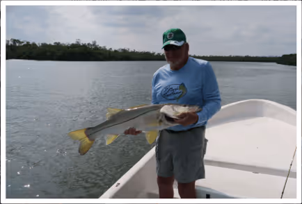 veteran holding a fish on a boat