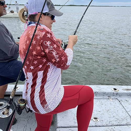 Angler in red and white star-patterned jacket fishing on a boat