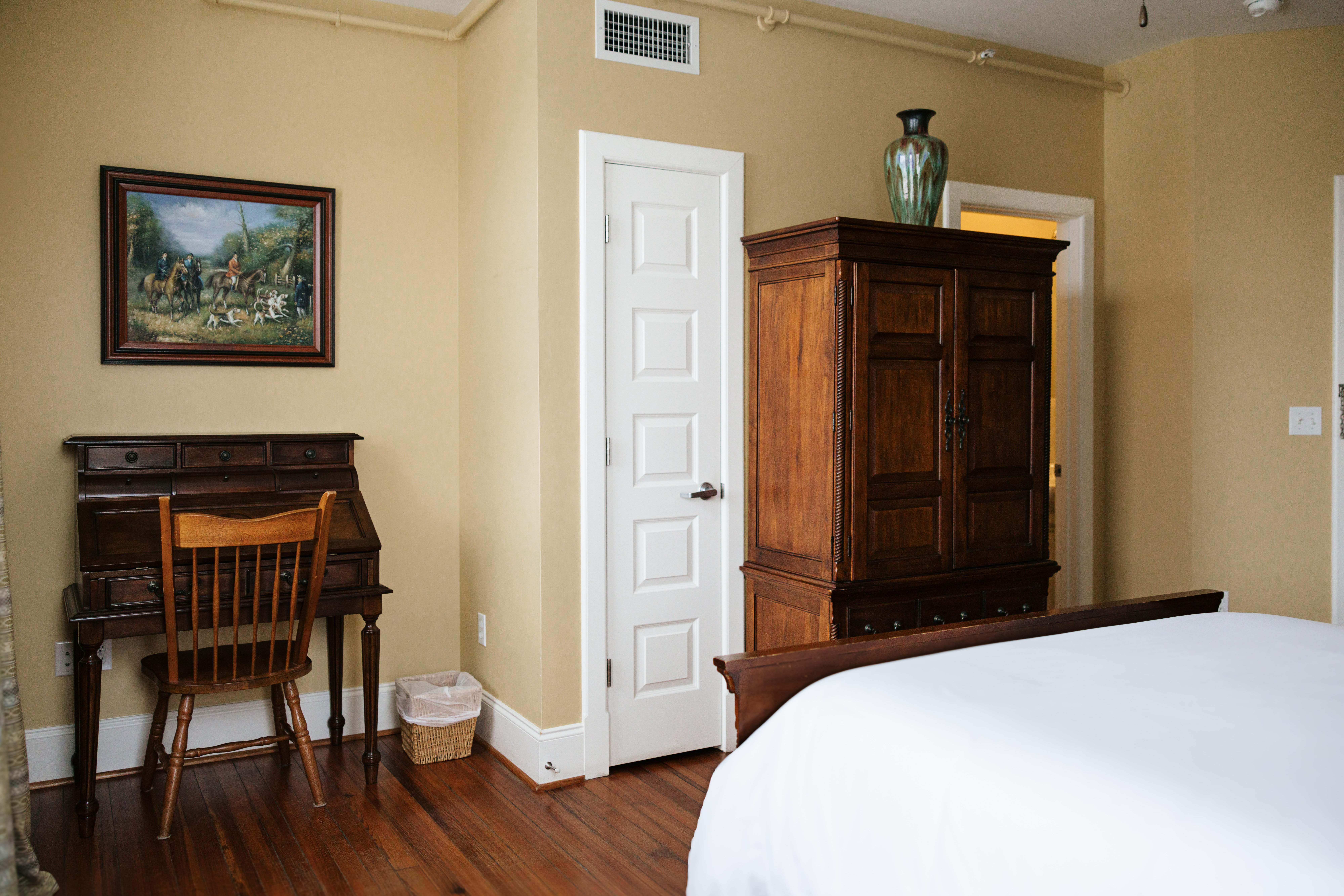 Desk, fox hunt painting, and armoire in The Hunt Room