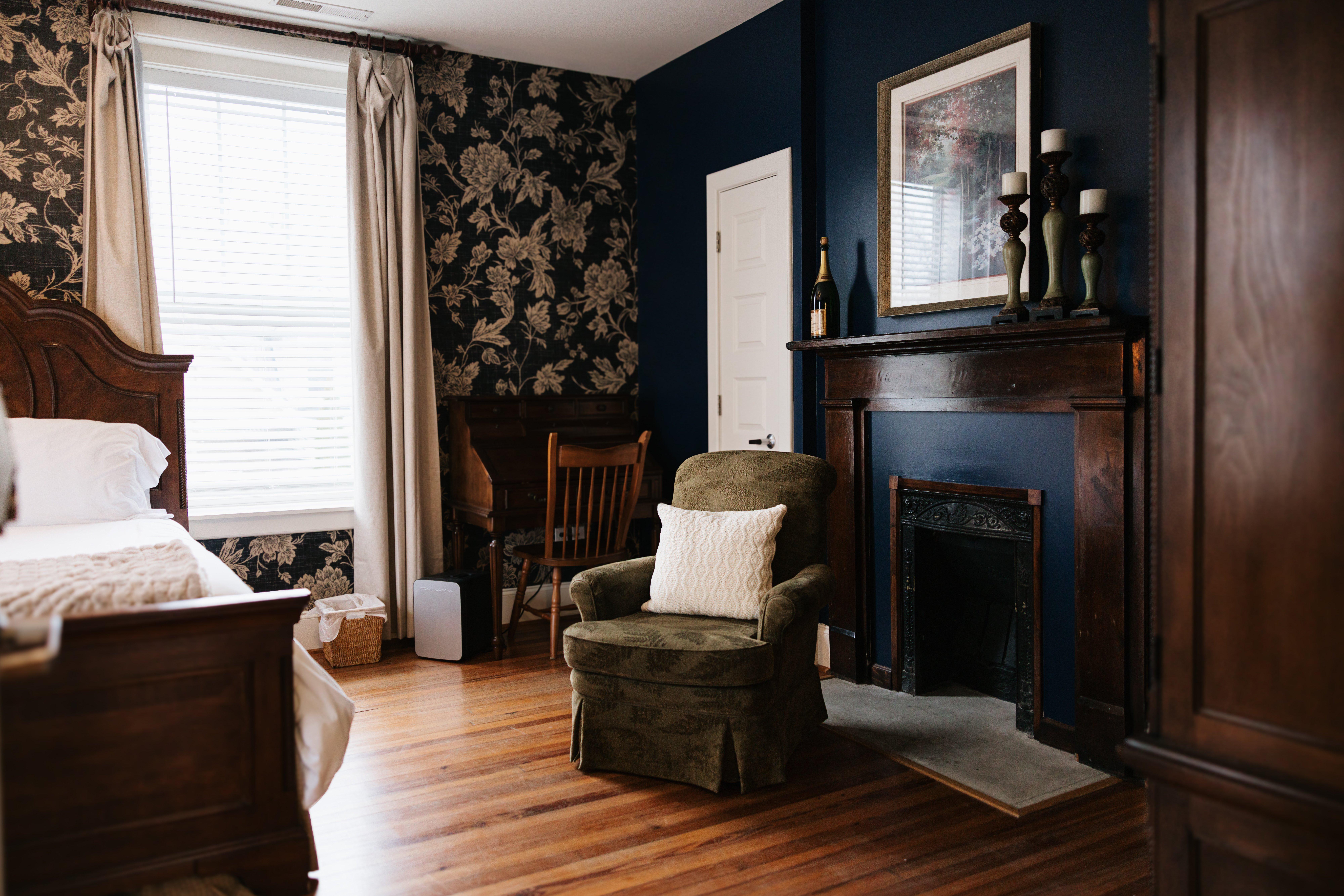 Wide view of The Georgia Room with desk, armchair, and fireplace