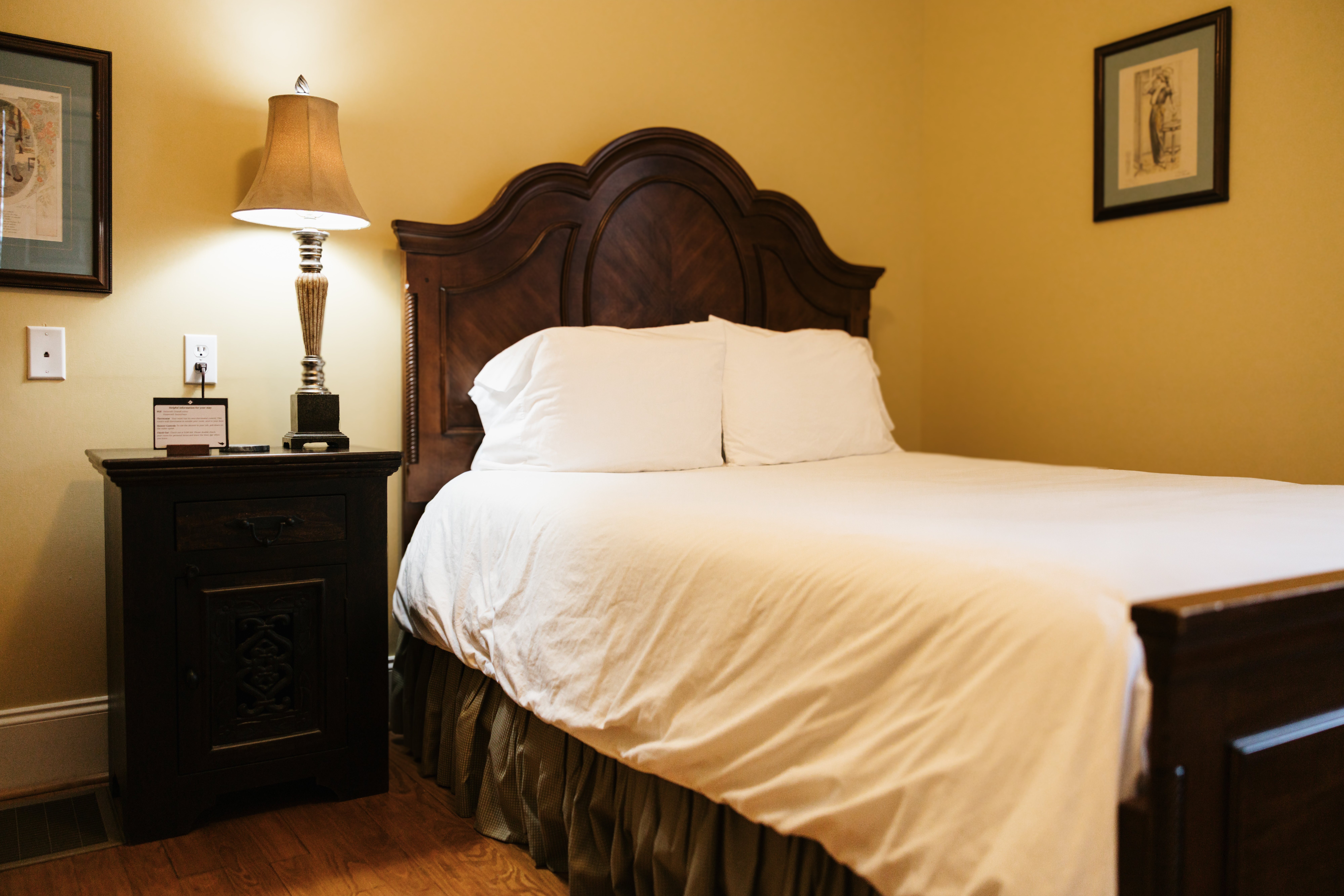 Queen bed in The Lyon Room with matching framed prints on either side