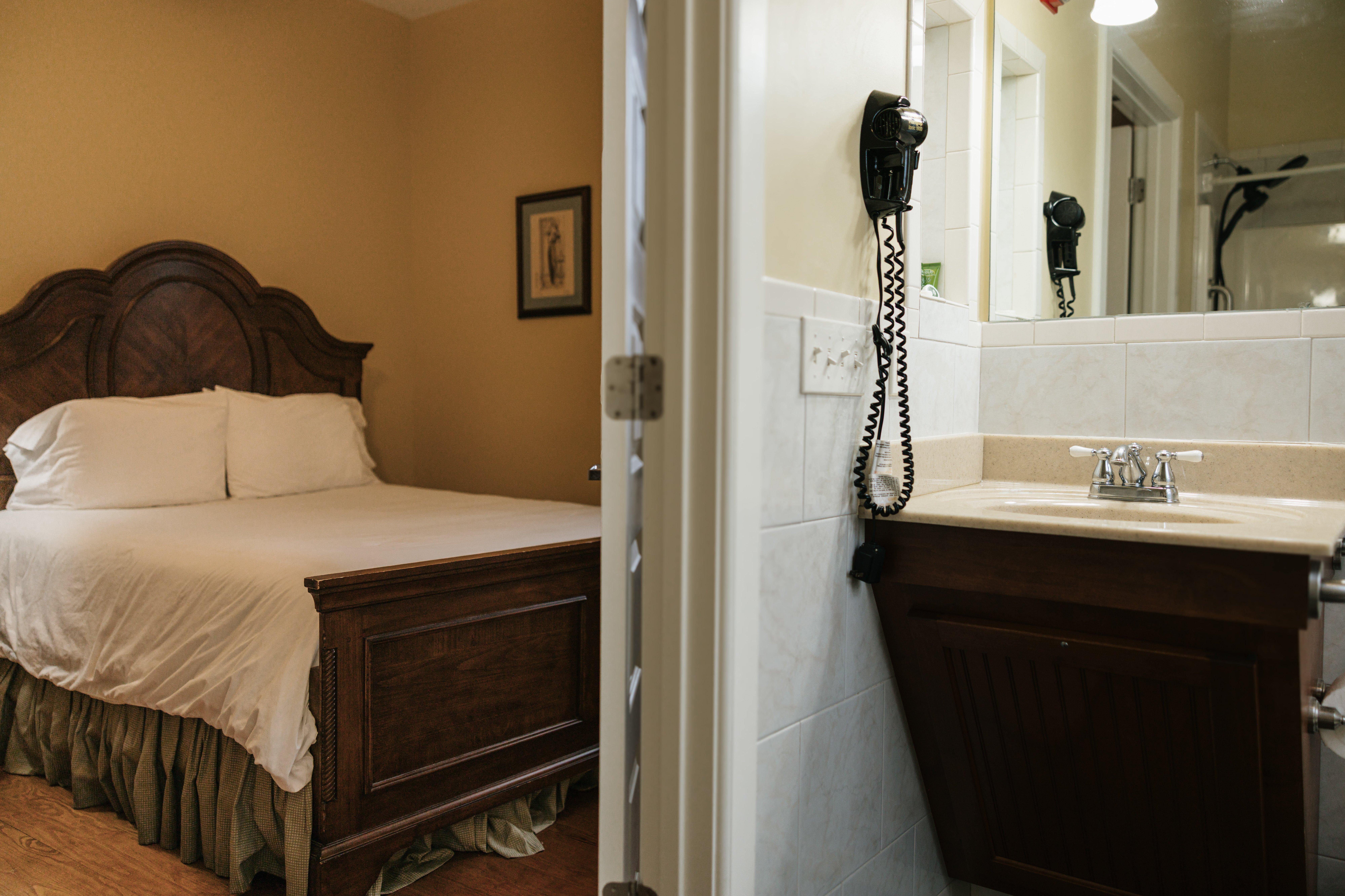 Queen bed and bathroom vanity through the open door in The Lyon Room