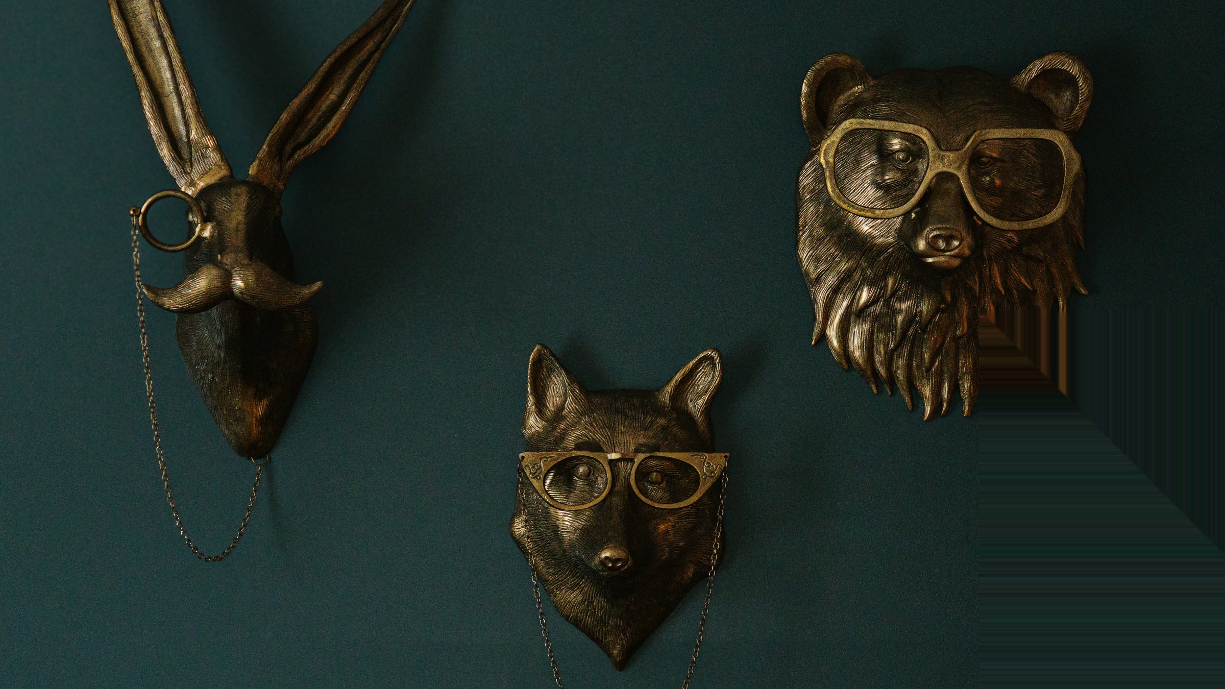 Mantle detail in the study at The Grand Lux Inn with whimsical brass animal wall art, fully in frame