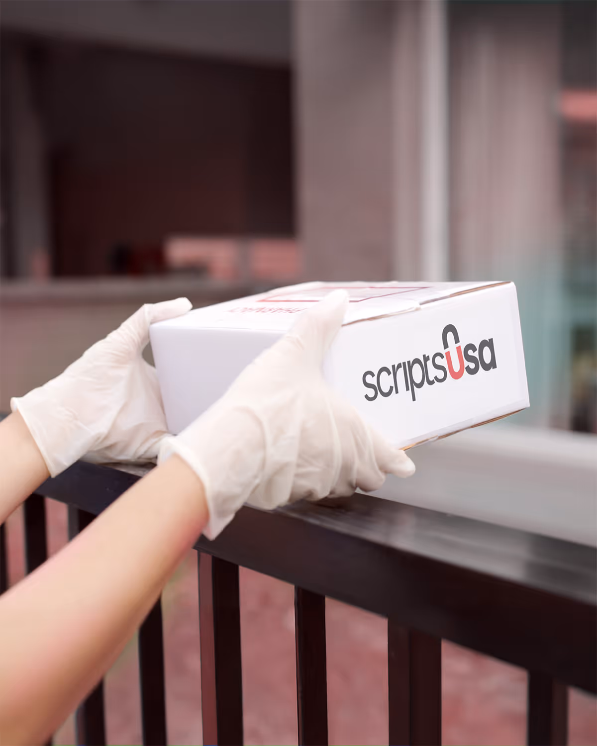 Hand holding a Scripts USA delivery prescription drugs box