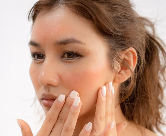 A brunette touching her face with both hands