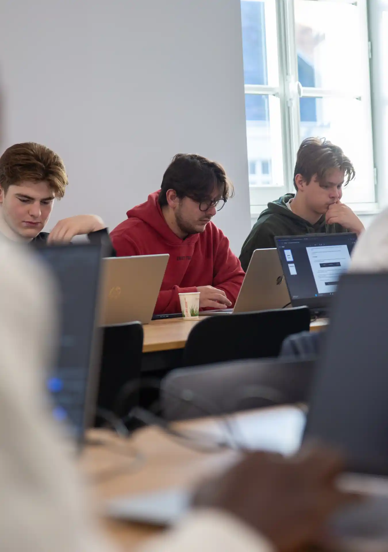 des étudiants sourient en regardant quelque chose sur un ordinateur