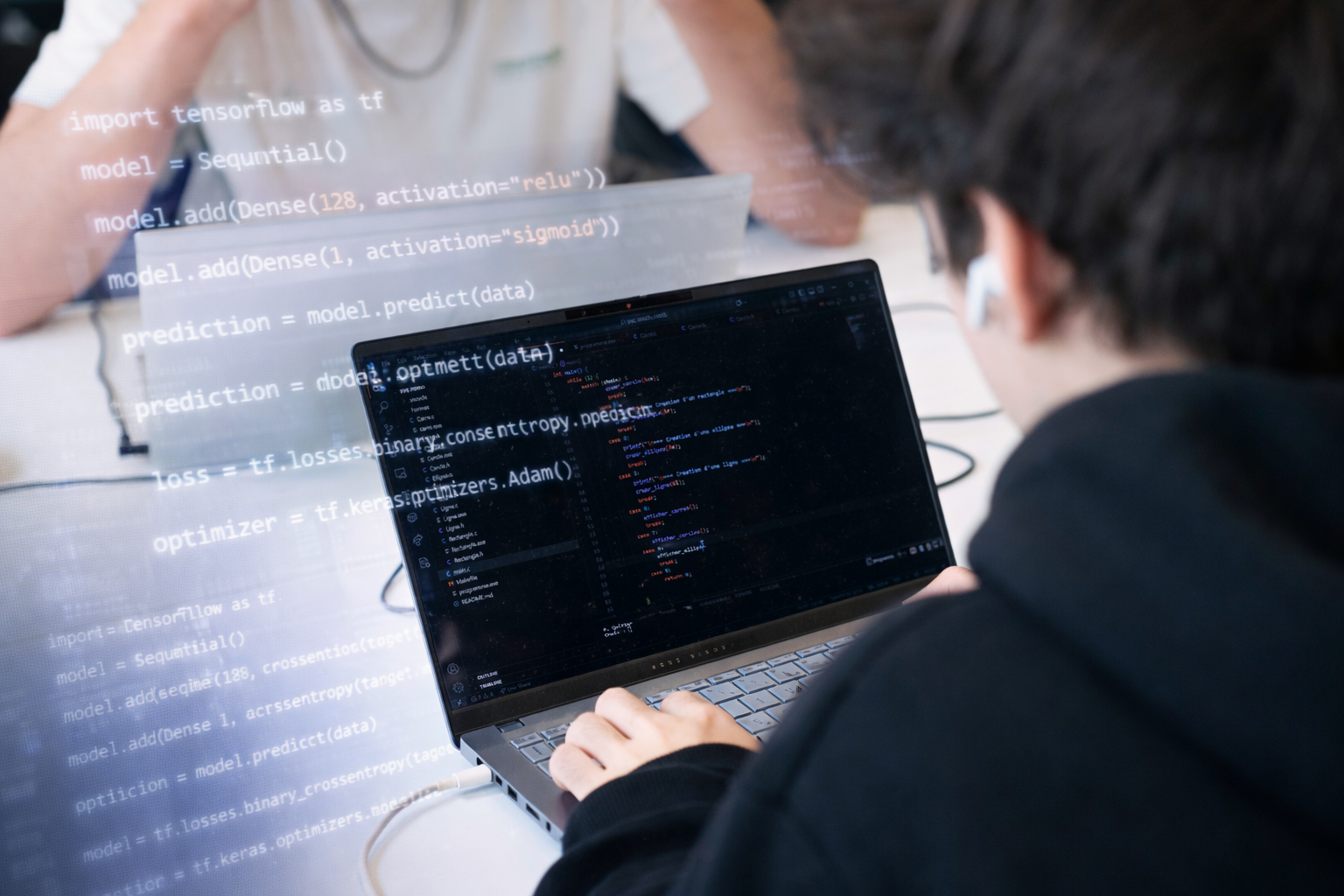 des étudiants sourient en regardant quelque chose sur un ordinateur