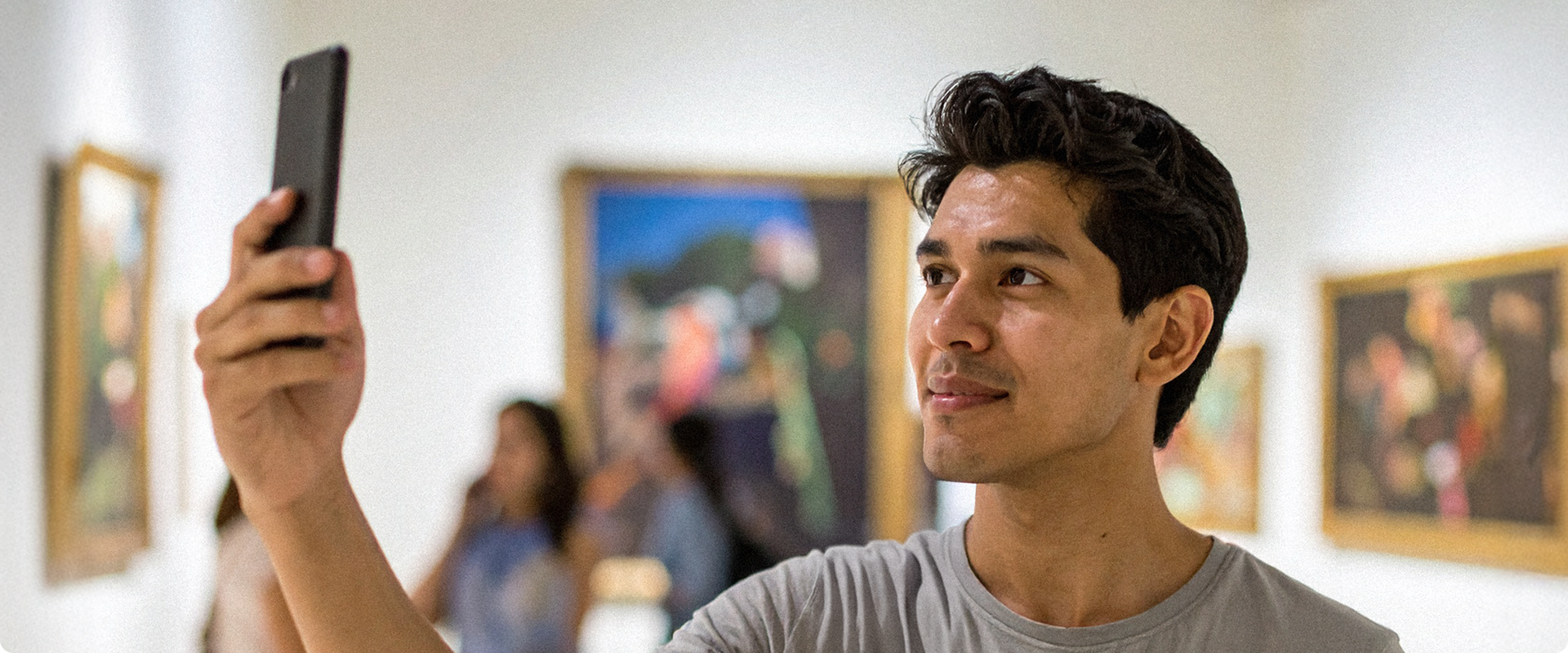 Visitor using smartphone to explore art gallery
