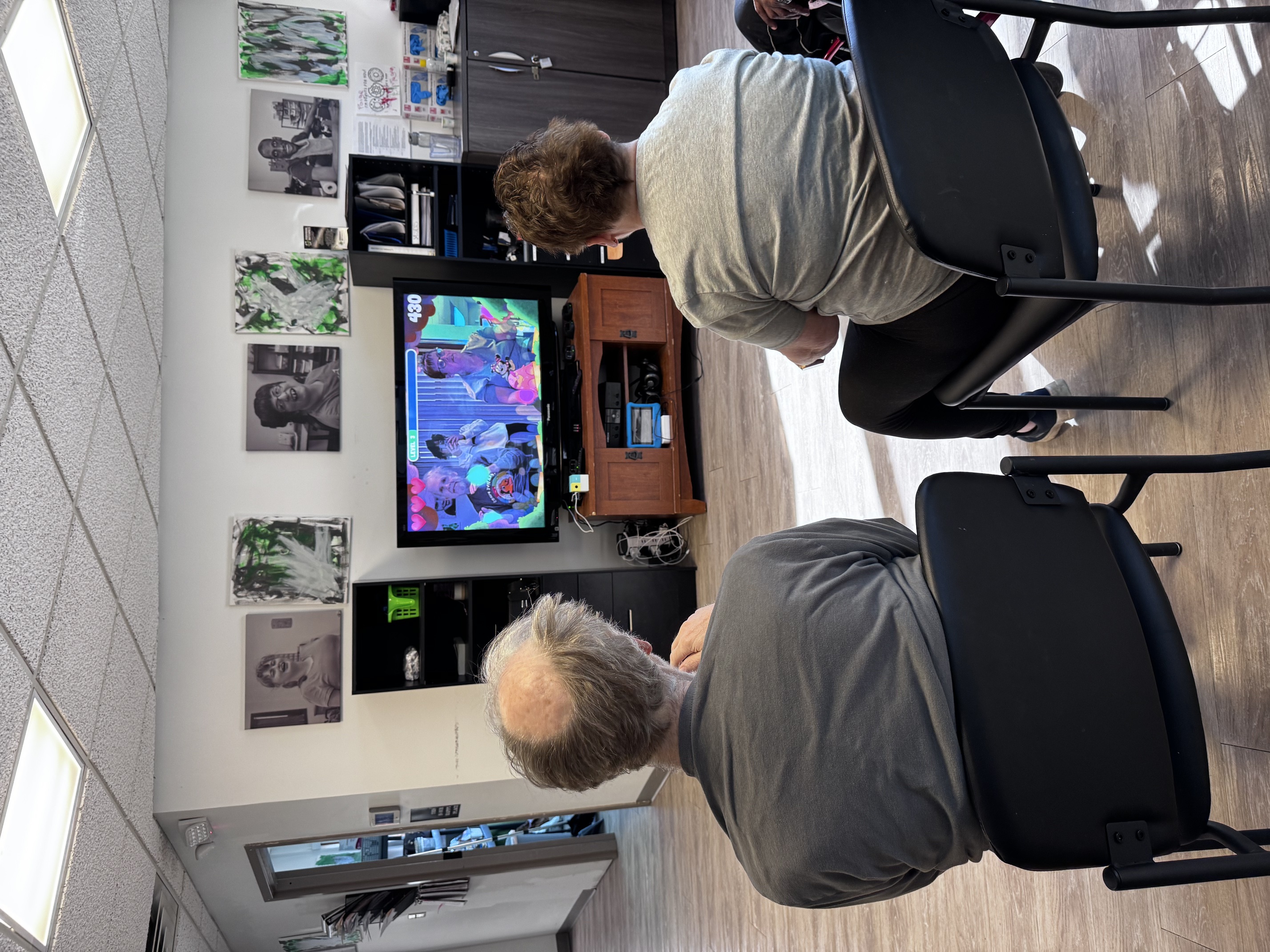 Two men playing Nex Playground while seated at Individual Outcomes, an adult day center.