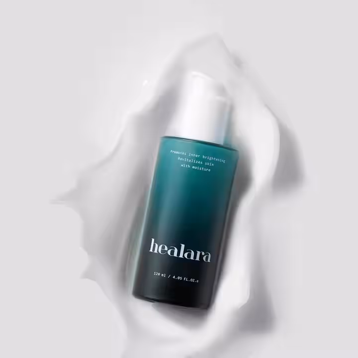A bottle of healara Core Lift Brightening Fluid splashed in white liquid
