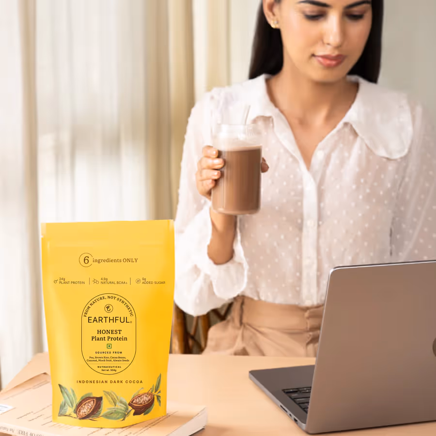 An artboard of a pouch of Honest Plant Protein – Indonesian Cocoa powder along with a glass held by a woman filled with mix of milk and powder.