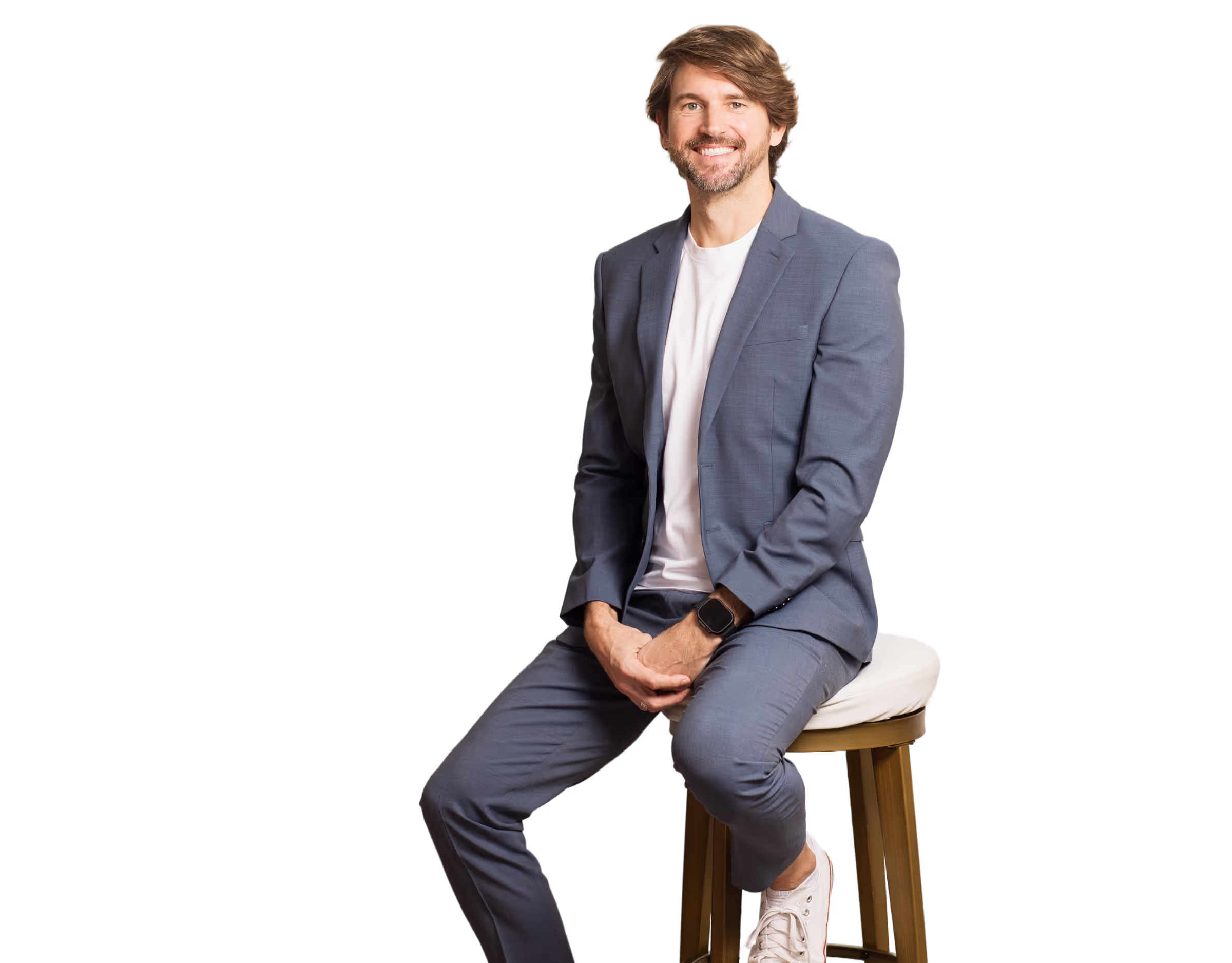 Travis McAshan sitting on a chair, posing for a professional portrait.