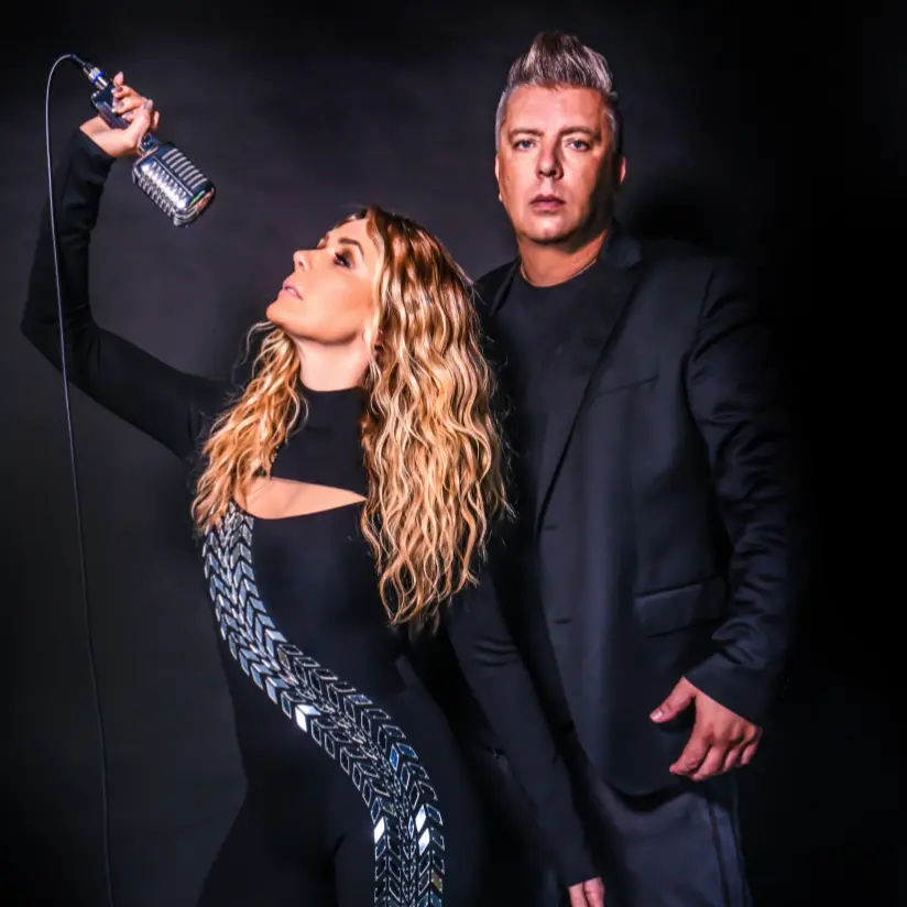 sylver boeken die naast elkaar staan in zwarte kledij en een oude microfoon vast heeft