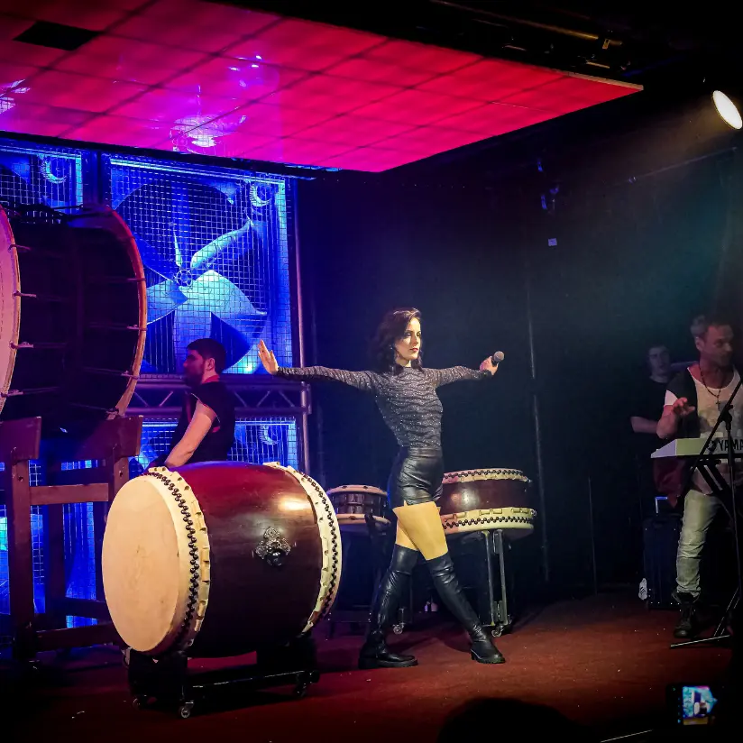 virtual zone boeken met grote drumstellen op podium en een danseres
