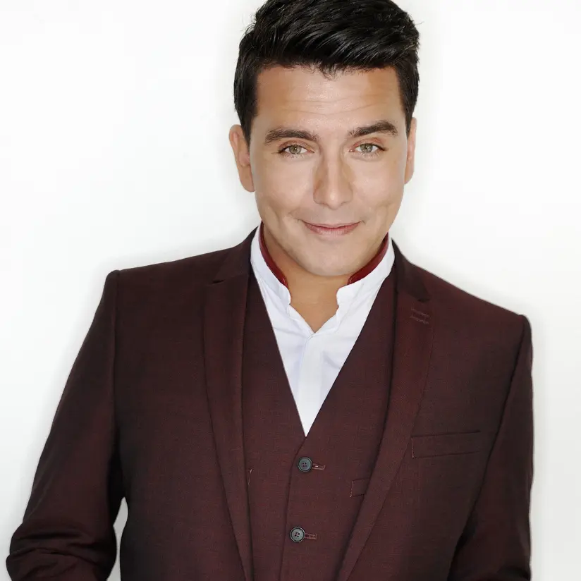 jan smit boeken die voor een witte achtergrond staat en een zwart kostuum aanheeft