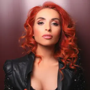 loredana boeken met rood haar en zwarte kledij kijkend in de camera