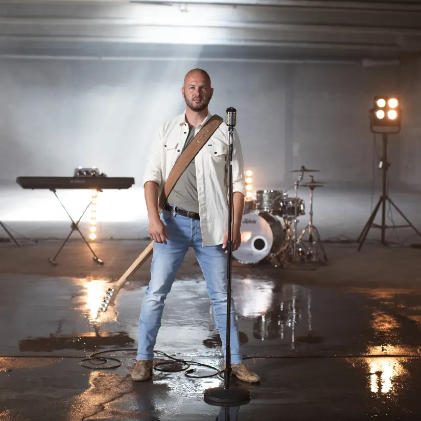 stan van samang boeken die een witte jas aanheeft en voor een oude microfoon staat