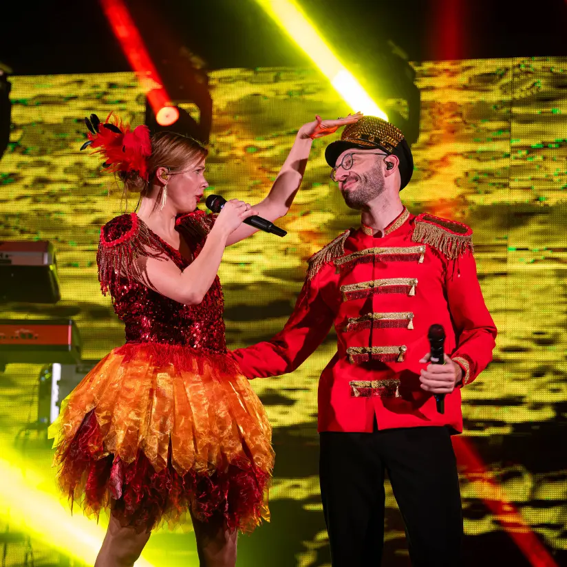 faute bendt boeken in rode kostuums met een gele achtergrond op podium
