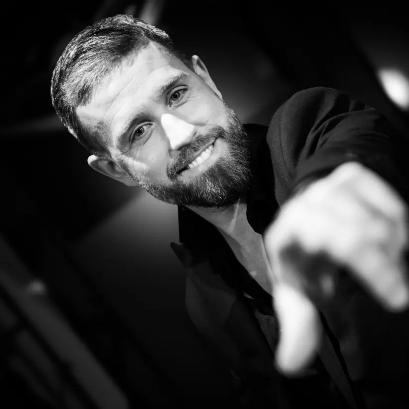 maarten cox boeken zwart wit foto en wijst naar camera