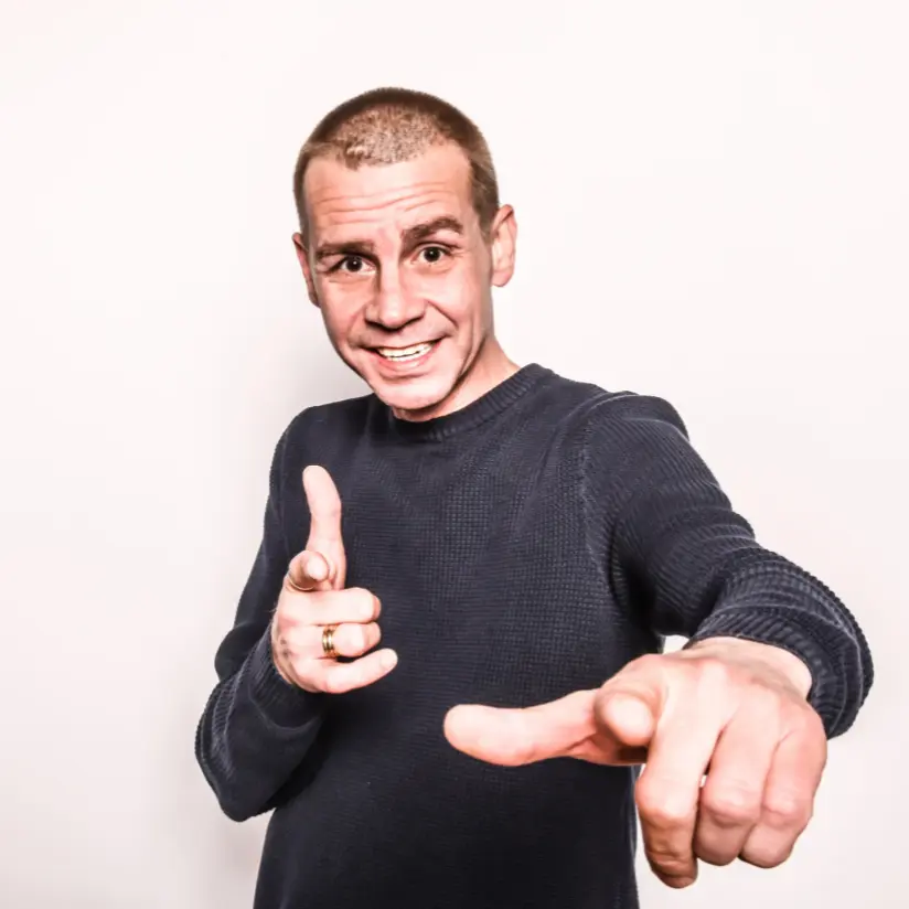 sam gooris boeken die wijst en lacht richting de camera