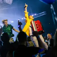 johan veugelers boeken op podium met accordeon en met zijn arm in de lucht