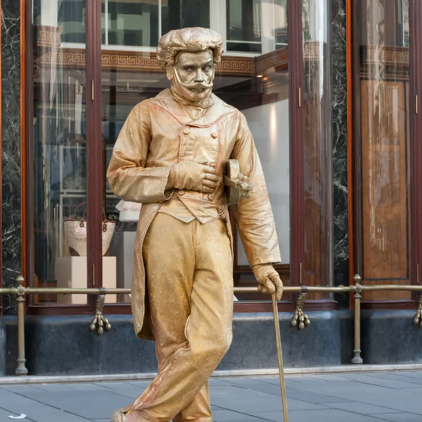 levend standbeeld boeken in het goud en staat recht met stok