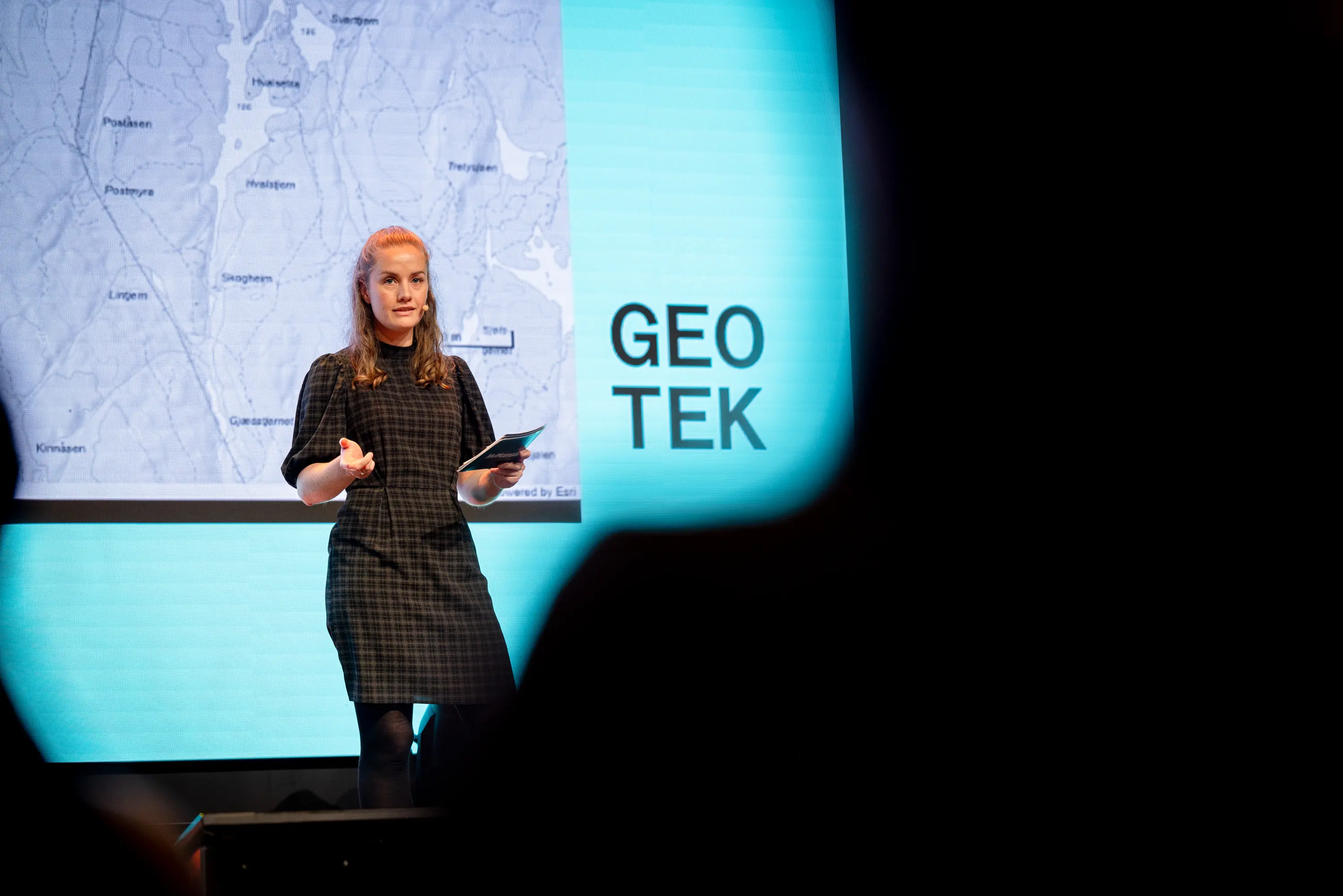 Julie presenterer kart på scenen foran en folkemengde