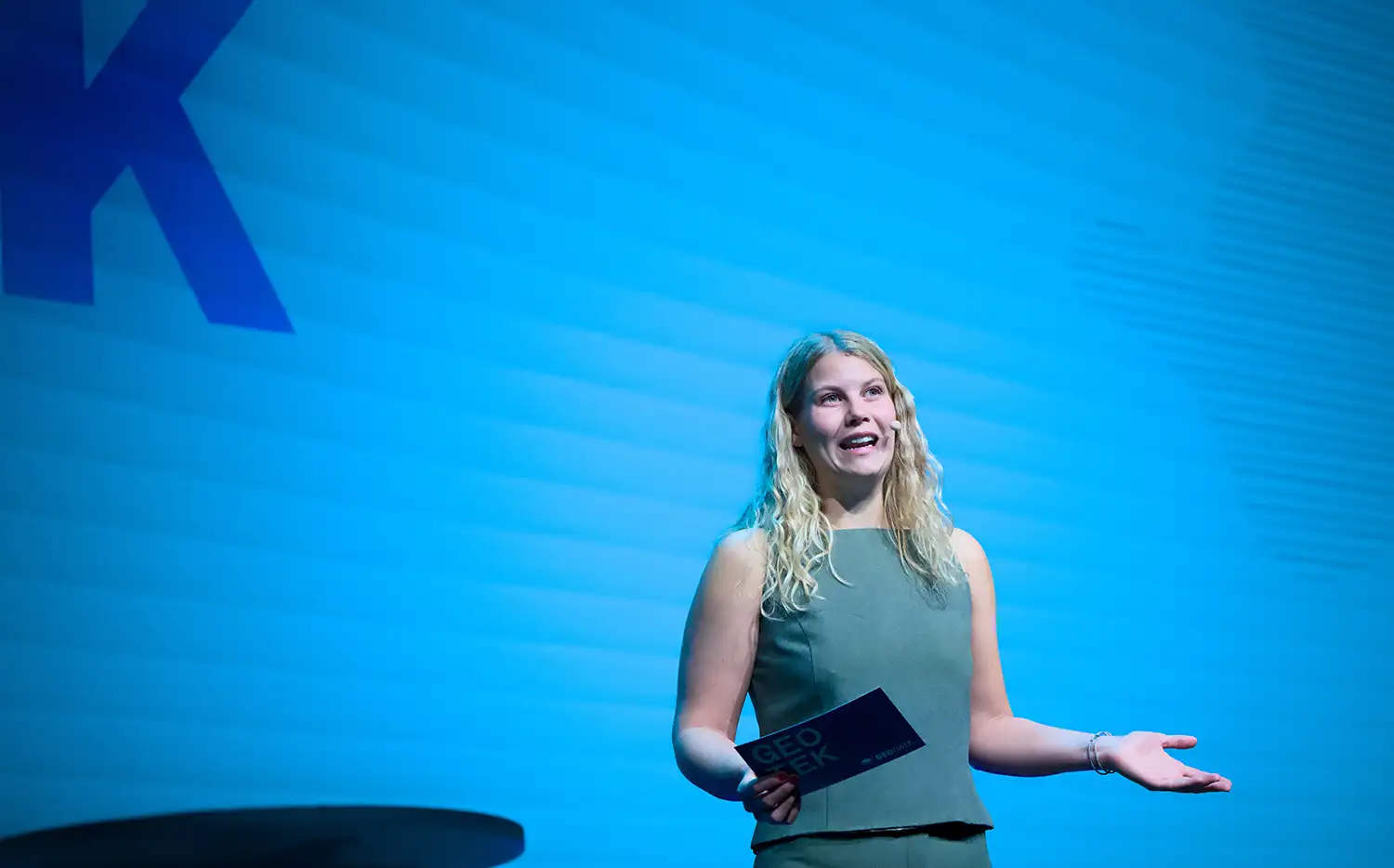 Mann på scenen presenterer byggning til publikum