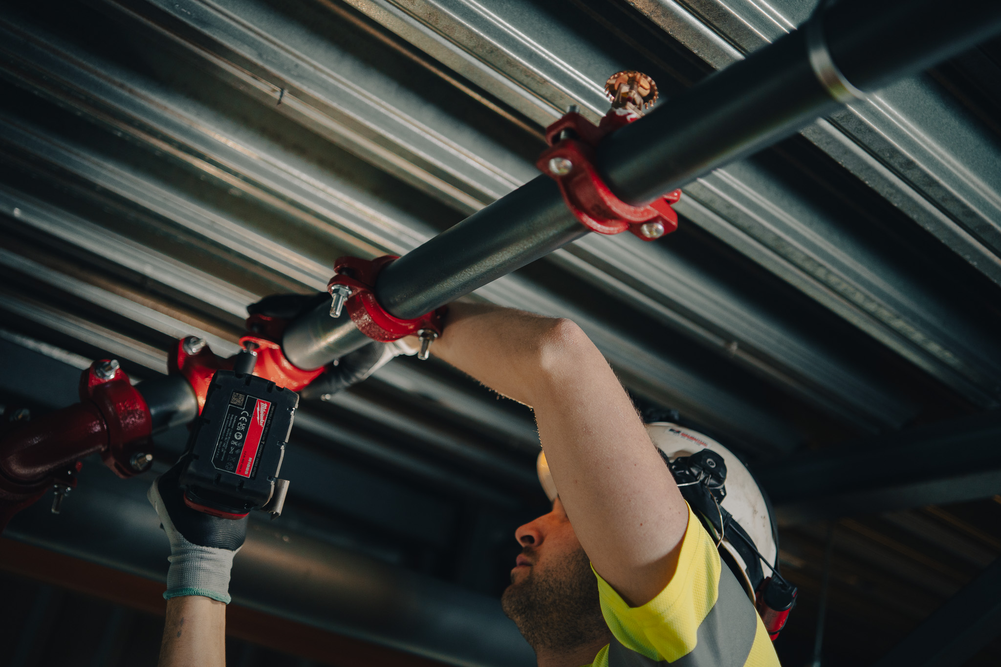 Mann som skrur på plass rør.