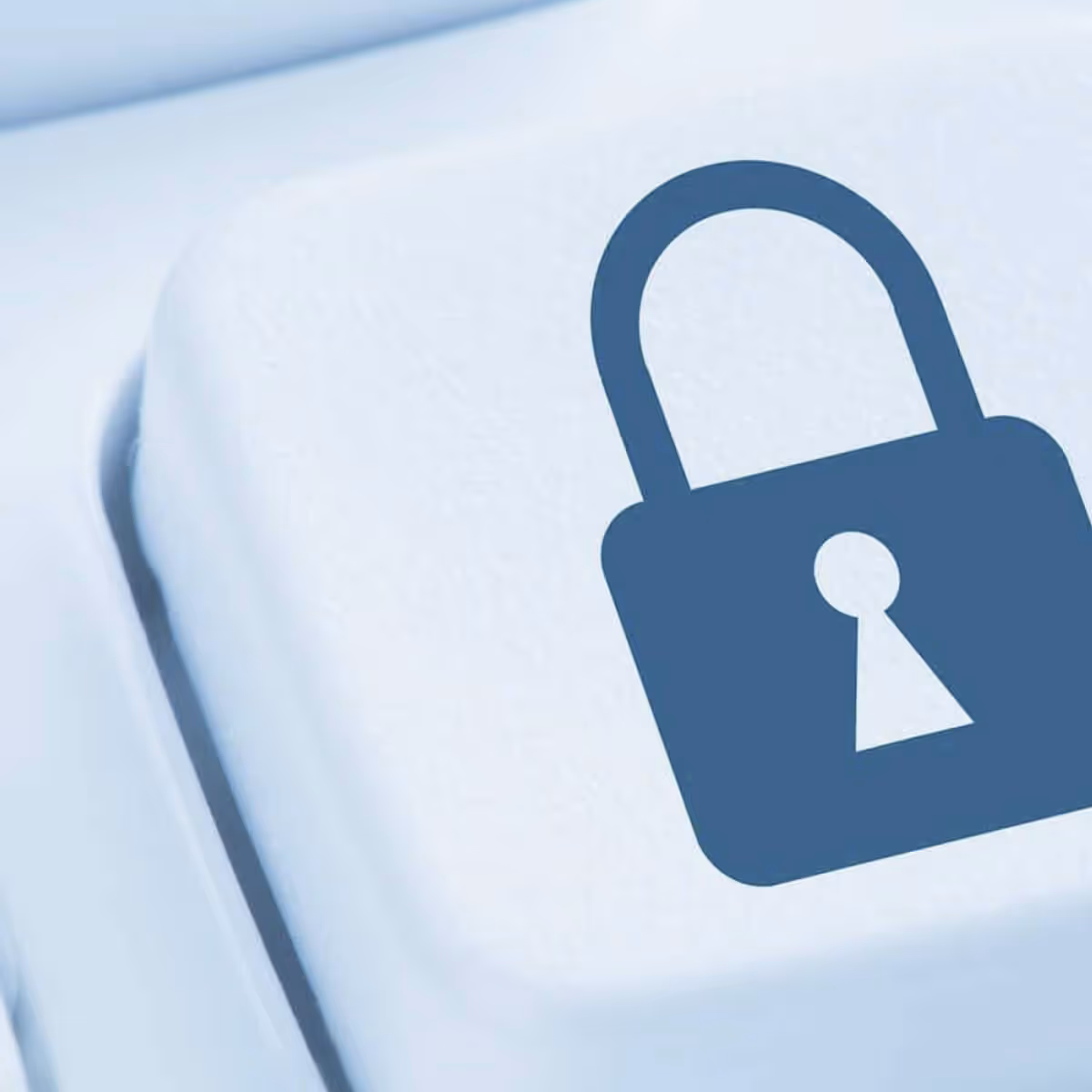 Nahaufnahme einer weißen Computertaste mit einem blauen Vorhängeschloss-Symbol.