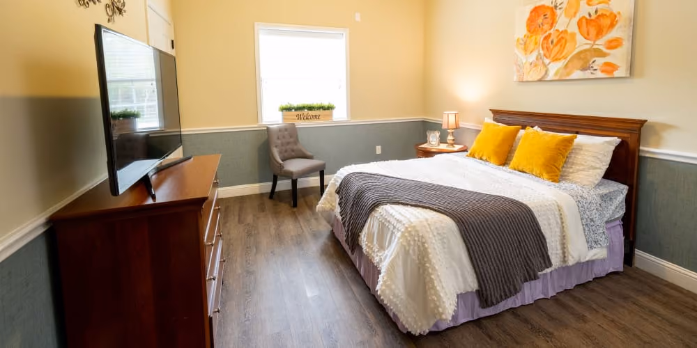 A spacious bedroom room with a flower painting and a TV