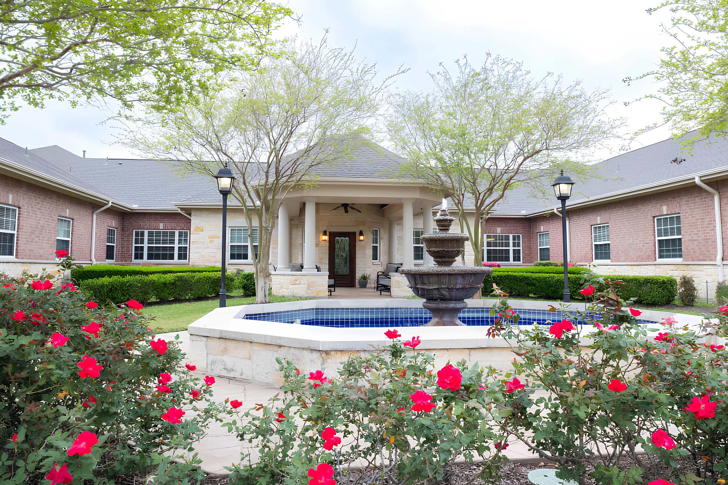 Beautiful courtyard with a fountain and red flowers.
