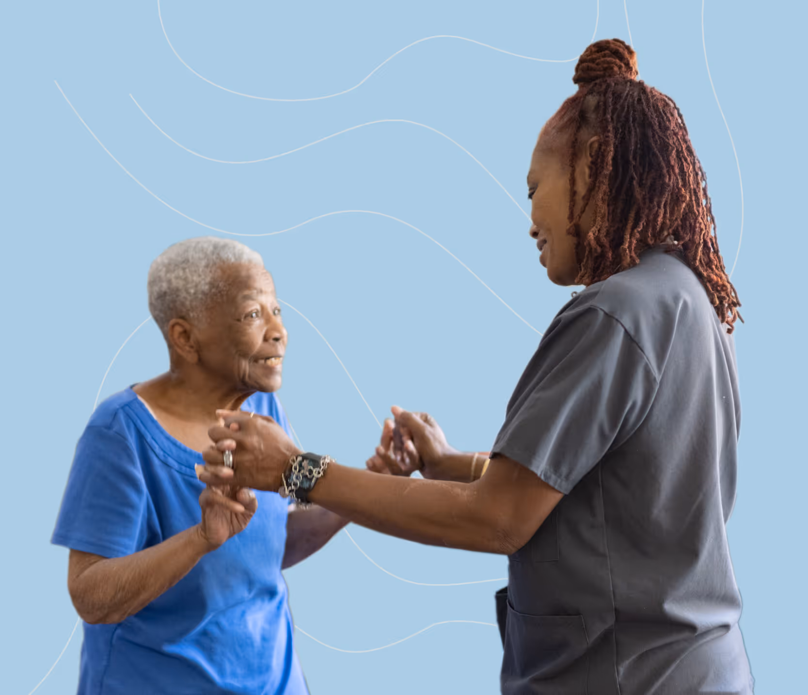 A caregiver in scrubs gently holding hands with A senior woman in a blue outfit as they engage in a dance or exercise in a well-lit room