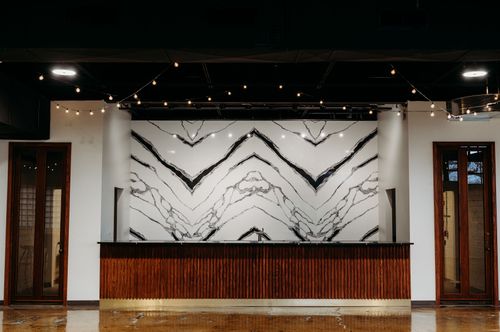 A picture of our stunning elevated bar. Black and white marble back splash with dark transposed counter tops. Dark wood underneath the bar top.