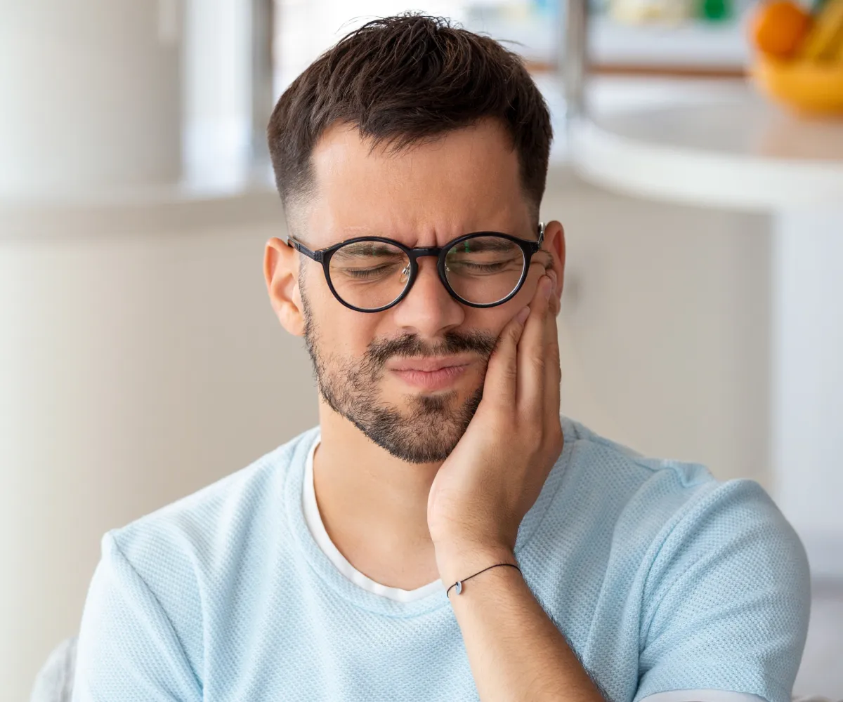Man touching his cheek in pain.