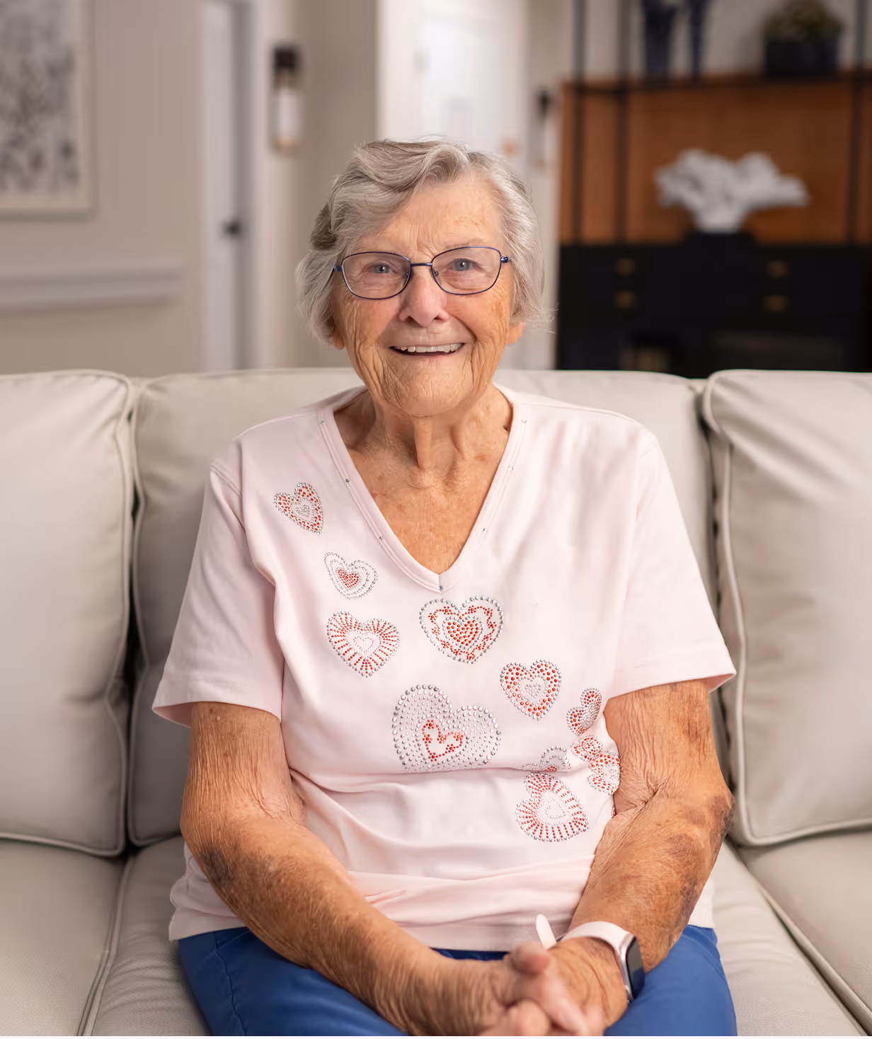 Happy senior resident relaxing in her cozy living space