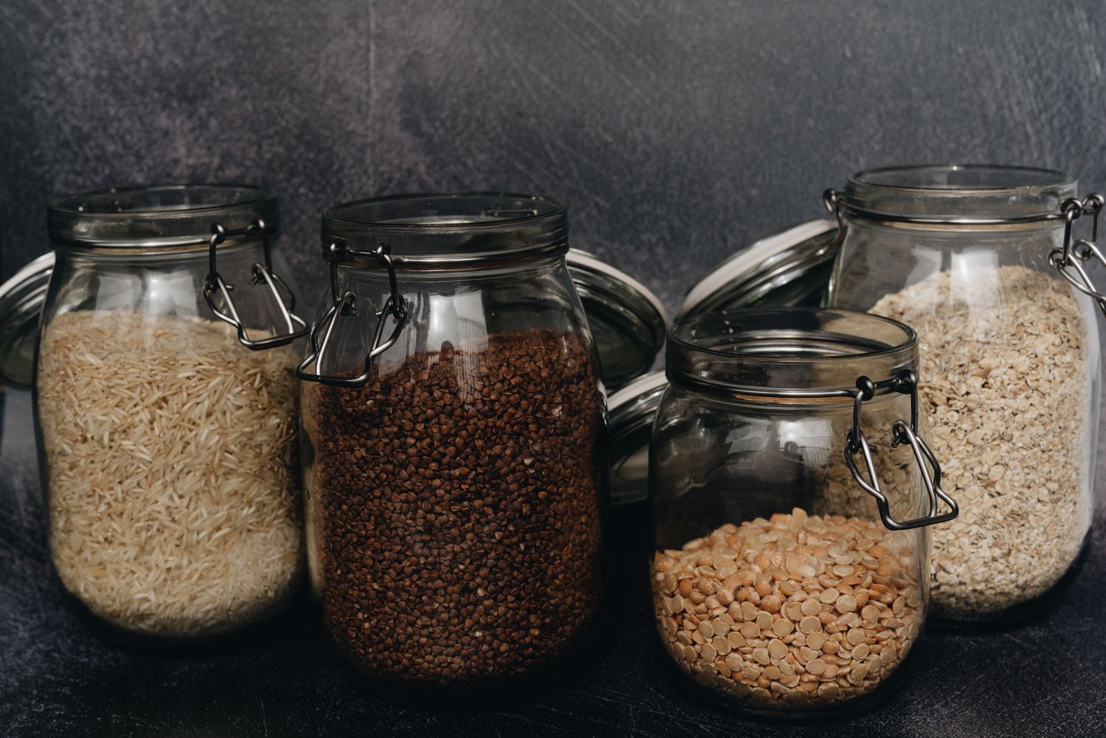 Tarros de cristal herméticos con arroz, legumbres y copos de avena, la forma de guardar los alimentos secos para que la polilla de la despensa no vuelva