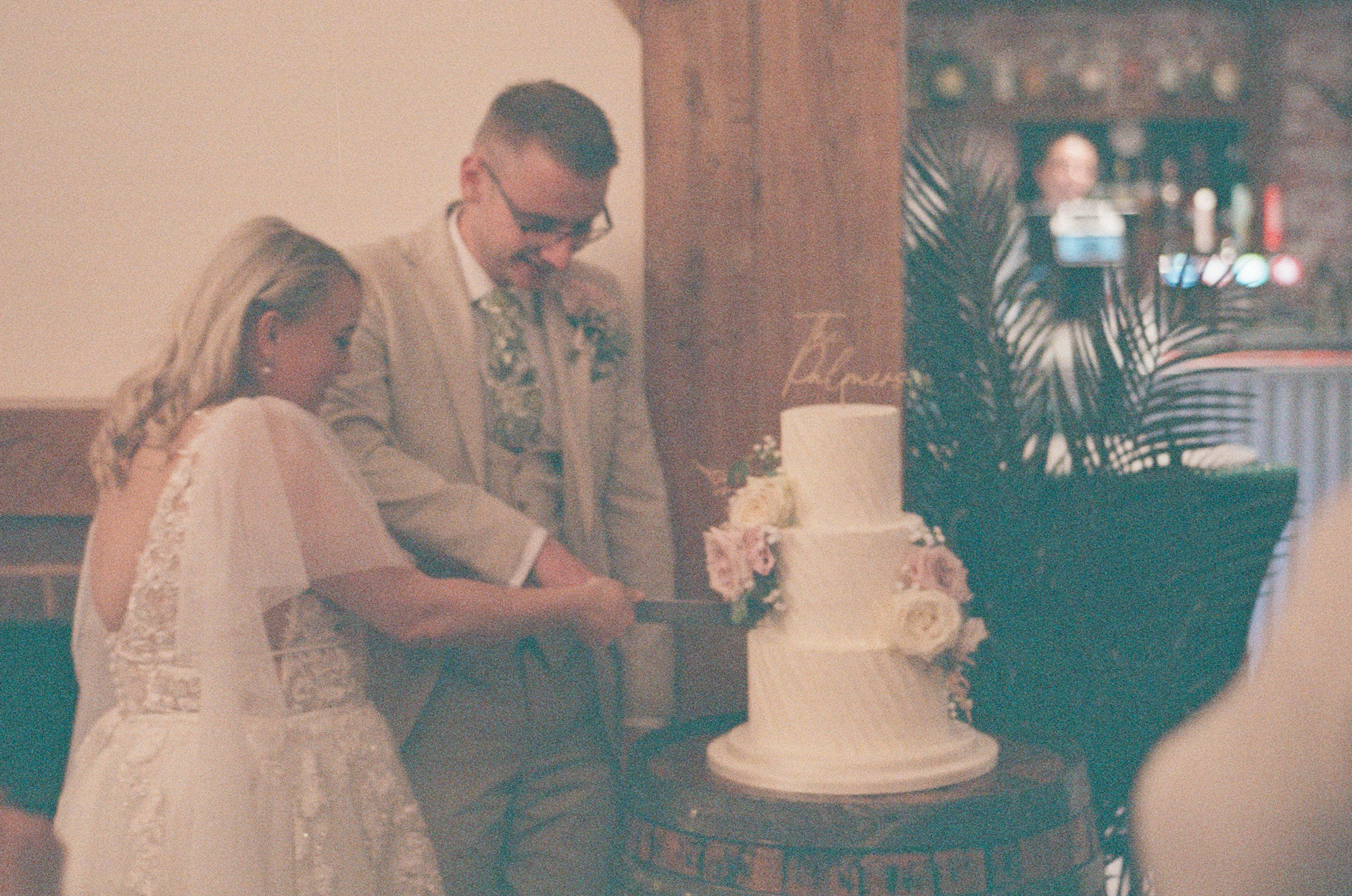 A happy couple cutting their three tier wedding cake