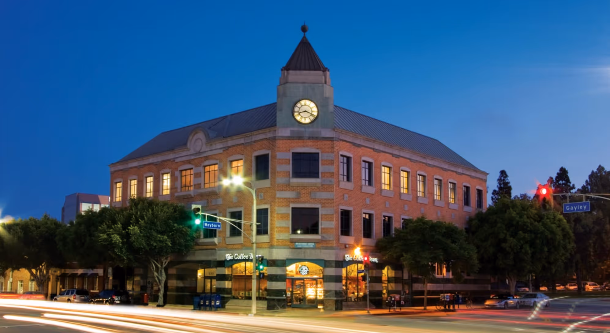 Image of the University of Southern California campus with iconic red-brick buildings, palm trees, and students walking across the central courtyard.