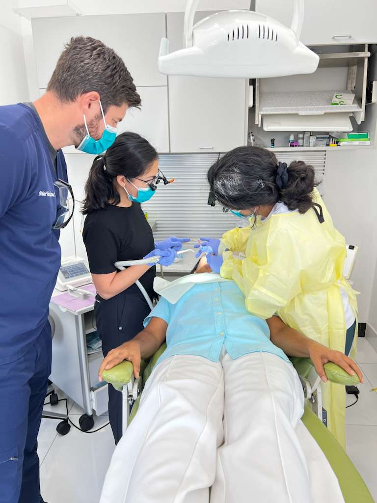 Clinicians reviewing a case with a patient in the dental chair