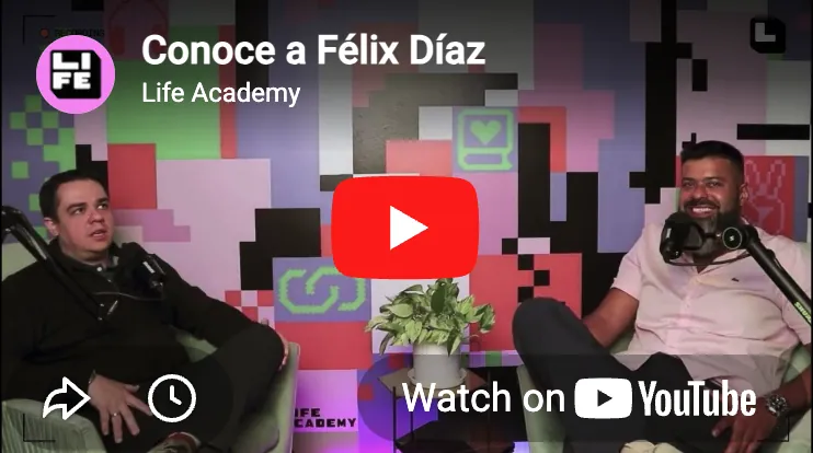 Captura de video de dos hombres sentados en sillas con micrófonos, texto dice 'Conoce a Félix Díaz, Life Academy', íconos de YouTube y reproducción.