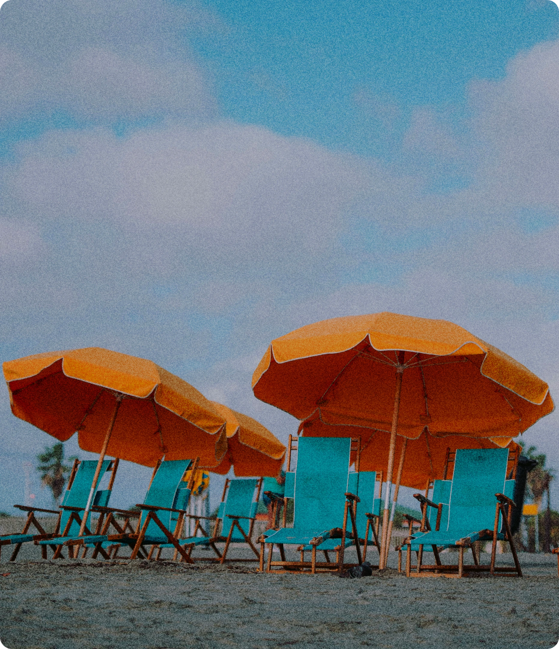 Photo de plage avec des parasols orange et des transats truquoise